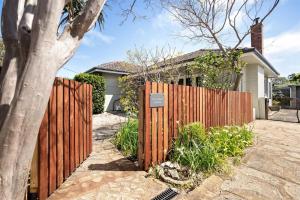 a wooden fence in front of a house at Elva Garden Cottage - Dog Friendly - Town Central in Margaret River Town