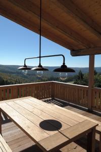 a wooden table on a deck with two lights at Romantikhütte Rothaarsteig in Schmallenberg
