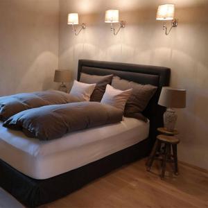 a bedroom with a large bed with two lamps at Romantikhütte Rothaarsteig in Schmallenberg