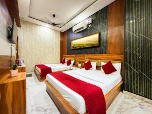 two beds in a hotel room with red pillows at Hotel Banke Bihari Dham in Vrindāvan