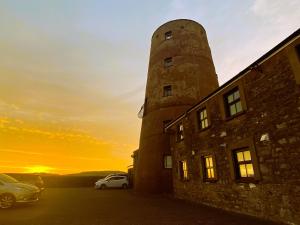 a lighthouse on top of a building with the sunset in the background at The Windmill in Castletown
