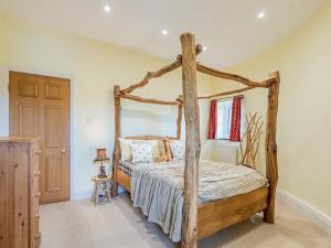 a bedroom with a wooden four poster bed at The Windmill in Castletown