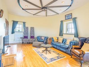 a living room with a couch and chairs and a chandelier at The Windmill in Castletown