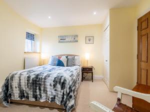 a bedroom with a bed with a blue and white blanket at The Windmill in Castletown +15 photos