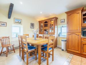 a kitchen and dining room with a wooden table and chairs at The Windmill in Castletown