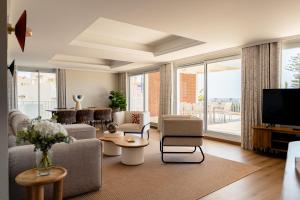 a living room with a couch and a tv at Résidence Carlton - Rénovée avec Piscine in Beaulieu-sur-Mer