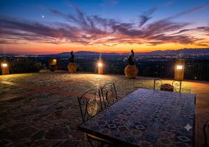 a patio with a table and chairs at sunset at Il Palagio in Vinci
