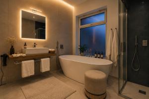 a bathroom with a tub and a sink at Syraka Design Rooms & Suites in Syracuse +25 photos