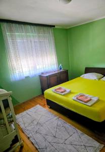 a green bedroom with a bed and a window at MiR in Londža