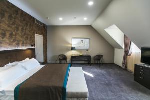 ein Schlafzimmer mit einem Bett und einem Schreibtisch in einem Zimmer in der Unterkunft Bon Hotel in Dnipro