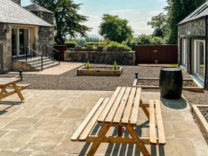 a wooden bench sitting on top of a patio at The Coach House in Auchtermuchty