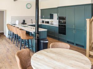 a kitchen with blue cabinets and a table with chairs at The Coach House in Auchtermuchty