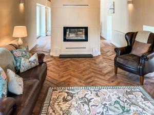 a living room with a couch and a fireplace at The Coach House in Auchtermuchty