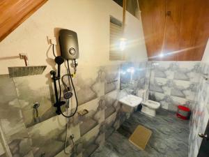 a bathroom with a shower and a toilet and a camera at Rainforest River Cabana & Villa in Deniyaya +50 photos