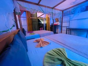 two beds in a room with towels on them at Rainforest River Cabana & Villa in Deniyaya