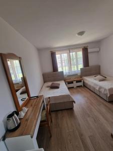a large room with two beds and a mirror at Престиж in Arbanasi