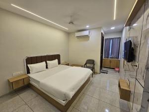 a bedroom with a bed and a television in it at Hotel Shiv Inn in Himatnagar