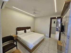 a bedroom with a bed and a chair in it at Hotel Shiv Inn in Himatnagar +4 photos