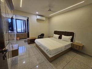 a bedroom with a bed and a chair in it at Hotel Shiv Inn in Himatnagar