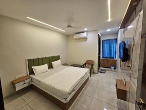 a bedroom with a bed and a television in it at Hotel Shiv Inn in Himatnagar