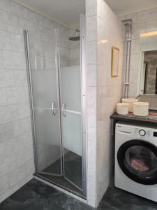 a shower in a bathroom with a washing machine at Muminhuset i Norberg in Norberg