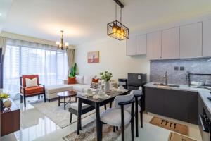 a kitchen and living room with a table and a couch at Luxury 1 bedroom in Westlands, Rooftop Pool, Next to Kempinski & GTC, Fast Wifi & Pool Table in Nairobi