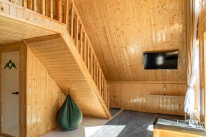 a wooden house with a staircase in a room at A-frame Sky in Karakol