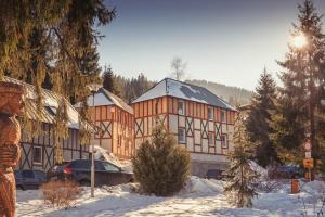 a building in the snow with cars parked in front at Chata 3 Domky 181 in Belá