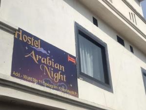 a sign on the side of a building with a window at Hostel Arabbian nights in Khajurāho