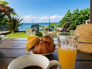 a table with a plate of pastries and a glass of orange juice at PK 35 in Apomaoro