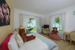 a bedroom with two teddy bears sitting on a bed at Sea Coco Resort in Ban Pak Nam Khem Nu