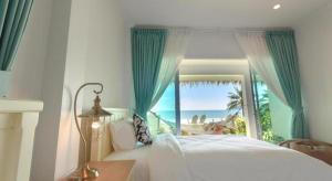 a bedroom with a bed with a view of the ocean at Sea Coco Resort in Ban Pak Nam Khem Nu +216 photos