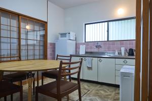 a kitchen with a table and chairs and a kitchen with a sink at PinKumano by WhyKumano in Nachikatsuura