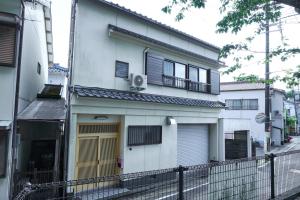 a white building with a porch and a balcony at PinKumano by WhyKumano in Nachikatsuura