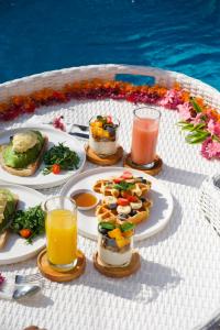 a table with plates of food and drinks on it at Uma Jineng Villa in Munggu