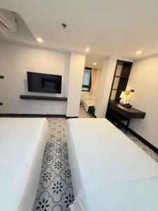 a hotel room with two beds and a flat screen tv at Hanoi Citadel Corner in Hanoi +12 photos