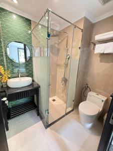 a bathroom with a shower and a toilet and a sink at Hanoi Citadel Corner in Hanoi