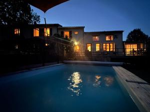 a large blue swimming pool in front of a house at Logis de Rault in Sainte-Ouenne