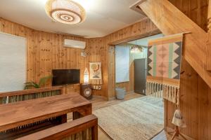 a living room with wood paneling and a flat screen tv at 감성제주스테이 in Songnang-dong