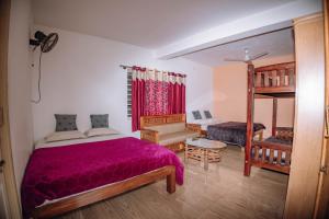 a bedroom with a bed with a purple bedspread at Sun Side Cottages in Madikeri