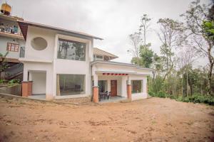 a house in the middle of a dirt field at Sun Side Cottages in Madikeri +35 photos