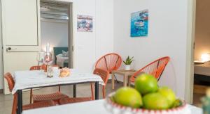 a dining room with a table and chairs with green apples at Marescià Siculiana Marina in Siculiana