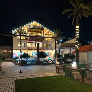 a large building with palm trees in front of it at الشريف in Irbid