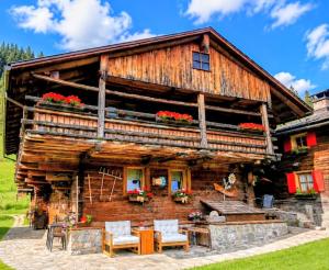 a log cabin with a table and chairs in front of it at Chalet - Margherita in Sappada