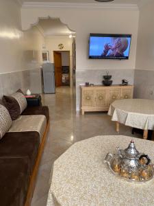 a living room with a couch and a tv on the wall at Najam café in Saïdia