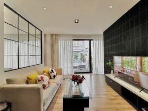 a living room with a couch and a tv at Jazz Living - Tropical Apartment 5 minutes walk from landmark 81 in Ho Chi Minh City