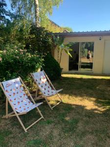 two lawn chairs sitting in the grass in front of a house at L Orée du Bois in Agnetz +20 photos