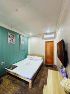 a room with a bed and a television in it at Cocomango's Resort in Taporok