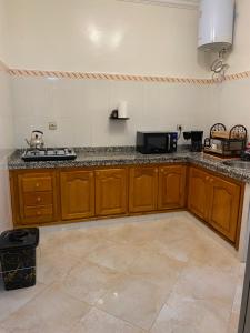 a kitchen with wooden cabinets and a counter top at Najam café in Saïdia