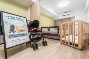 a room with two bunk beds and a sign and a baby crib at ESLEAD HOTEL Namba South Ⅲ in Osaka